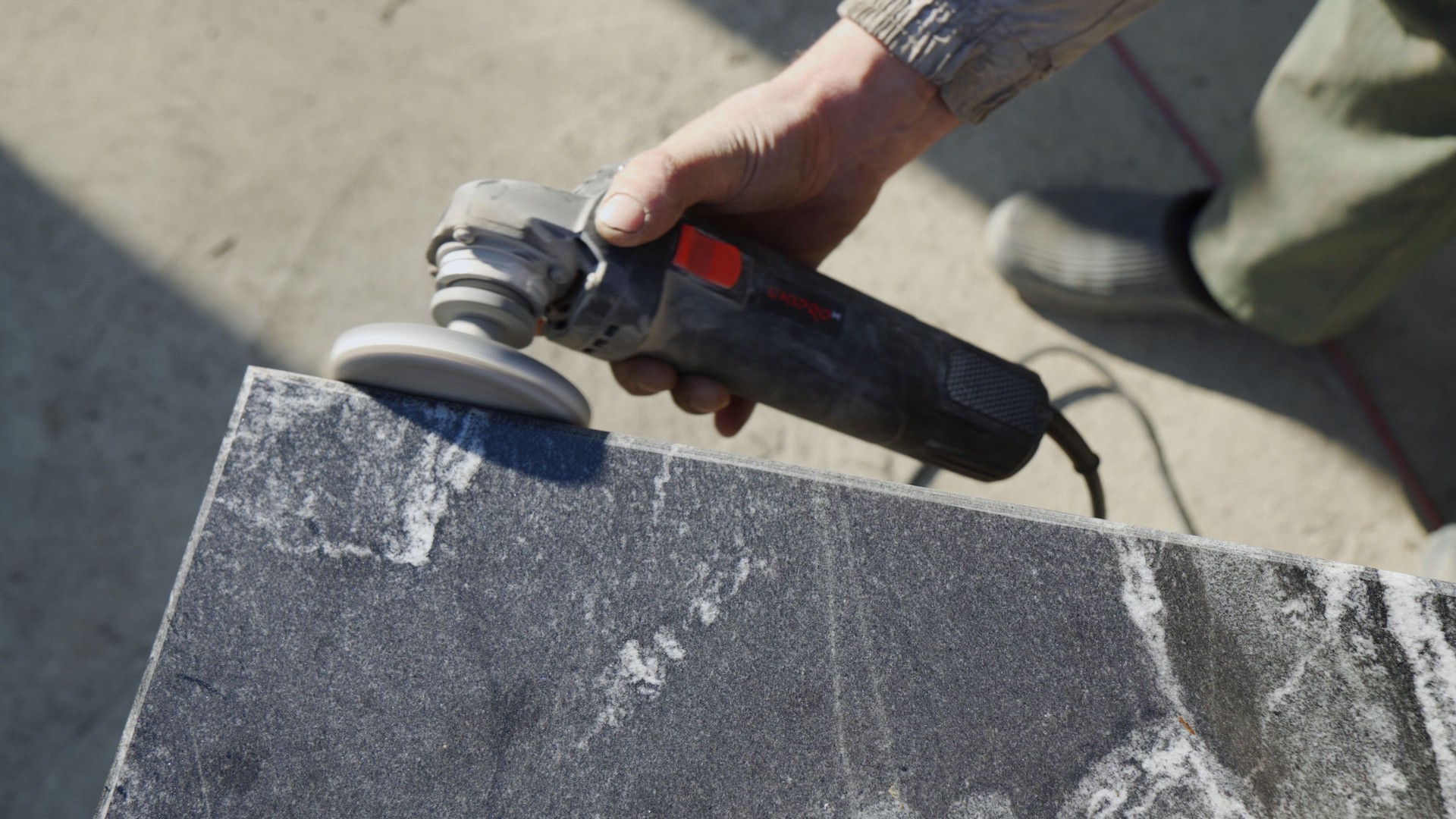 Processing granite with a grinder. Industrial tool for stone processing.